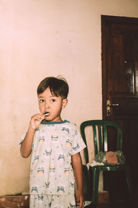 Portrait of cute boy looking away while eating candy