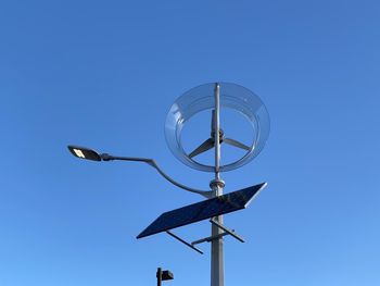 Low angle view of telephone pole against clear blue sky