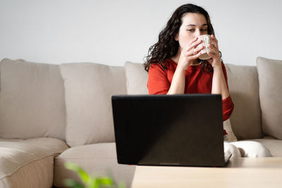 Businesswoman using laptop while sitting at home