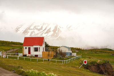 Small isolated house on the main road on a small icelandic island. snowy mountains 