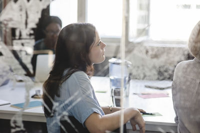 Businesswoman with colleagues in board room during brainstorming session