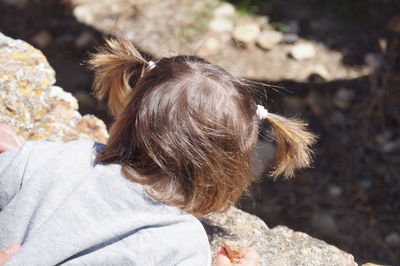 High angle view of girl leaning on retaining wall