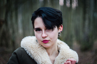 Portrait of woman wearing pink lipstick in forest