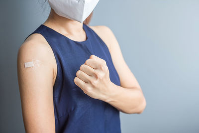 Midsection of woman standing against white background