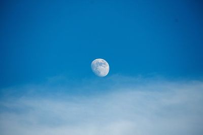 Low angle view of moon against blue sky