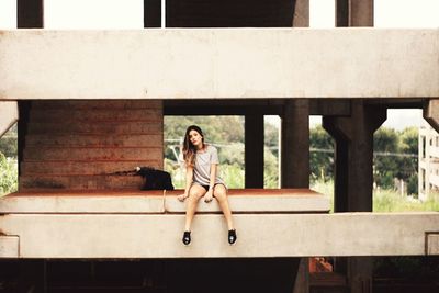 Portrait of woman sitting at incomplete building