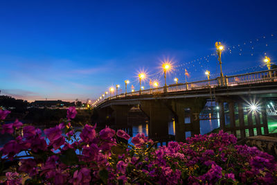 Illuminated bridge against sky at night