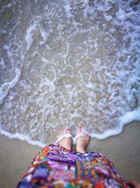 Low section of woman standing on beach