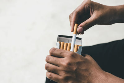 Close up man hand holding peel it off cigarette pack prepare smoking a cigarette. packing line up.