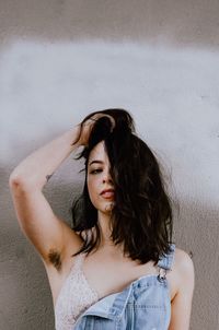 Portrait of young woman against wall