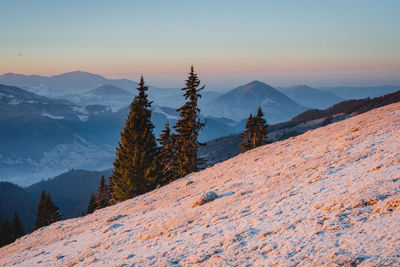 Scenic view of snowcapped mountains against sky during sunset