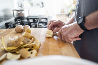 Senior man cutting potatoes on the chopping board