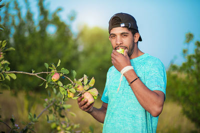 Portrait of man holding ice cream against plants