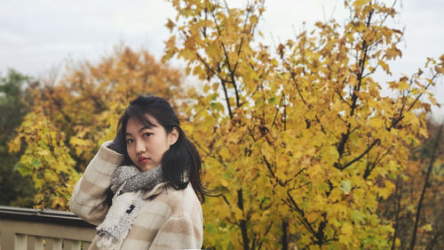 Portrait of young woman with autumn leaves