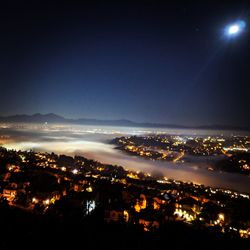 High angle view of illuminated buildings against sky at night