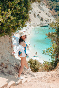 Full length of young woman standing at beach