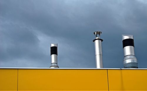 Low angle view of smoke stack against sky