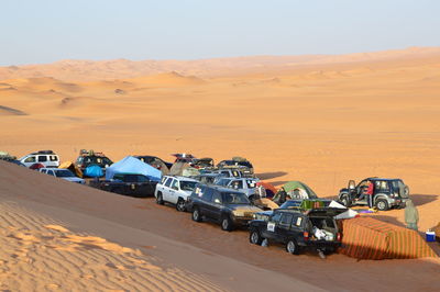 Cars on desert against sky