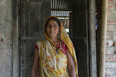 Portrait of woman wearing sari standing in front of door