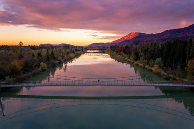 Aerial view of man standing on bridge over salzach river at sunset, salzburg, austria.