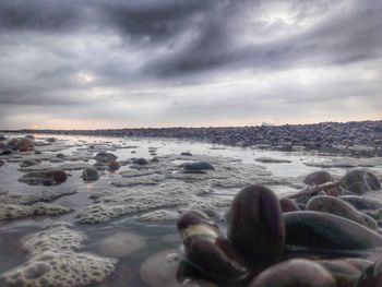 Scenic view of beach against cloudy sky