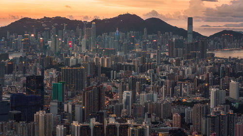 Illuminated cityscape against sky during sunset