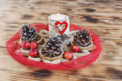 High angle view of christmas decoration with burning candle on table