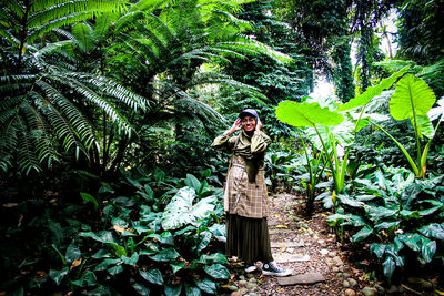 Portrait of woman standing by plants