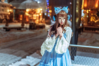 Beautiful young woman standing at night