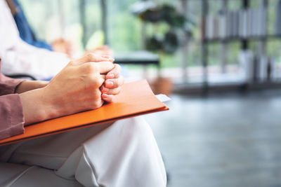 Midsection of woman holding book