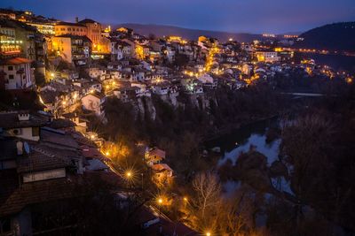 Illuminated cityscape against sky at night