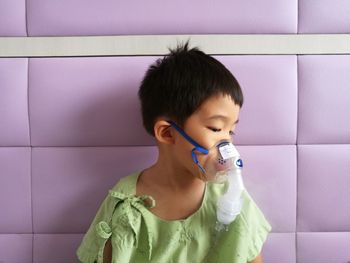 Close-up of cute boy wearing oxygen mask