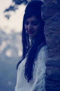 Portrait of beautiful woman standing against black background