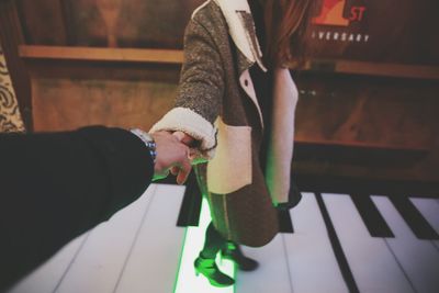 Couple holding hands on piano flooring