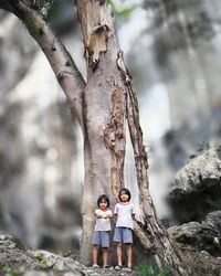 Girl standing on tree trunk