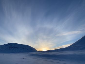 Scenic view of snowcapped mountains against sky during sunset