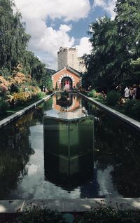 Reflection of building in pond against sky