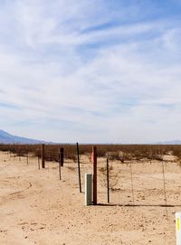 Wooden posts on field against sky