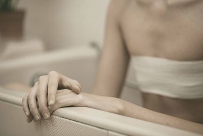 Woman sitting in bathtub