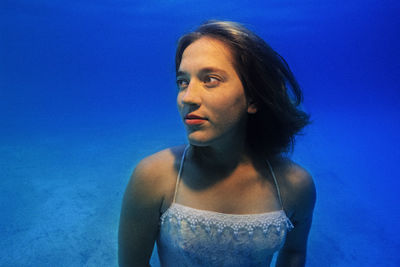 Portrait of a girl underwater in a pool.