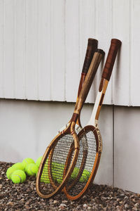 Rackets with tennis balls by wall