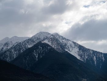 Scenic view of snowcapped mountains against cloudy sky