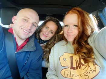 Portrait of smiling young woman sitting in car