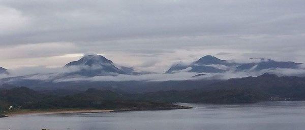 Scenic view of snowcapped mountains against cloudy sky