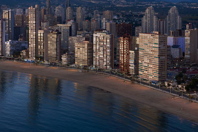 View of city by sea at dusk