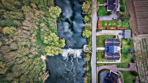 Aerial view of river amidst trees and houses