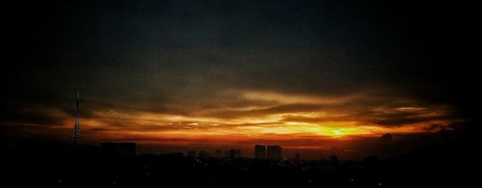 Silhouette cityscape against sky during sunset