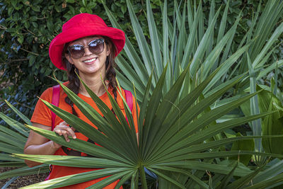 Portrait of smiling woman by plants outdoors