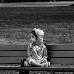 Girl wearing costume while sitting on bench at park