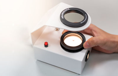 The gemologist's expertise in her laboratory fixes the value of precious stone of the polariscope.